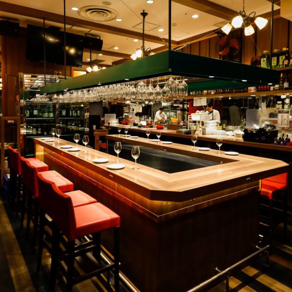 【銀座のトラットリア】入ってすぐのオープンキッチンは大迫力!!次々入る注文を手際よく作る姿は圧巻♪高い天井は開放感があり、店内奥のステージで奏でられるピアノの演奏がより良い音となって全体に響き渡ります!!スタッフの声やお客様の会話が心地良い喧騒を生み出し、現地さながらのイタリア食堂をお楽しみください♪