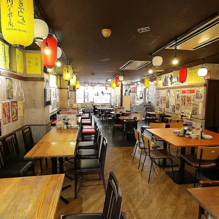 提灯が彩るレトロな空間で楽しむテーブル席。活気ある店内で、仲間との食事や仕事帰りの一杯に最適です。