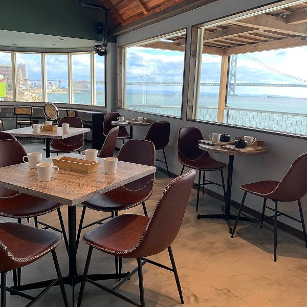 從大窗戶可以眺望明石海峽的咖啡廳空間。寬敞的店內可以欣賞到美麗的景色。