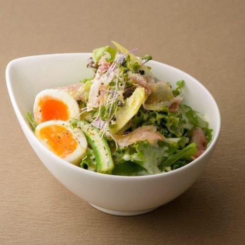Caesar salad with raw ham and soft-boiled eggs