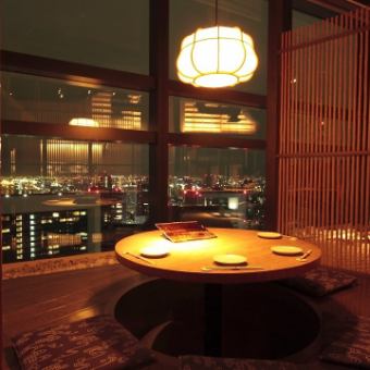 円状のテーブルで掘りごたつ使用となっているこちらのお席は、4名様までご着席頂ける夜景を展望出来るお席となっております。半個室ですので比較的に周囲を気にせず美しい夜景をみながらゆっくりとした時間をお過ごし頂けます。