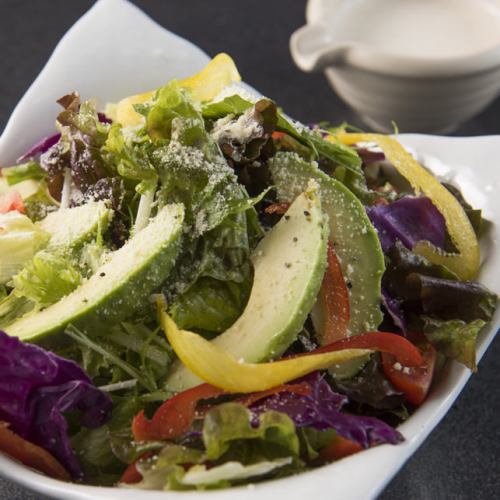 Avocado Caesar salad with colorful vegetables