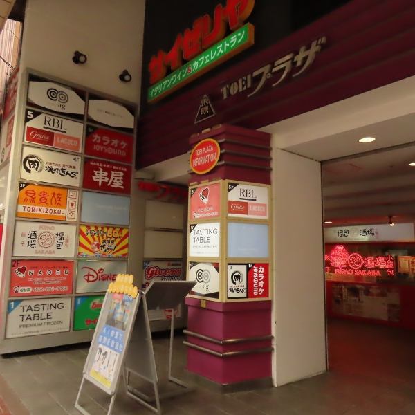 待ち合わせに便利な「ディズニーストア」の1階が当店です!迷う心配なしの分かりやすい立地が目印。店内に入ると、真っ赤な提灯とレトロポップなネオンサインが輝く、非日常的な空間が広がります。