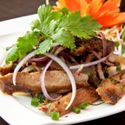 Grilled pork belly with spicy herbs "Namtok Kom Yang"