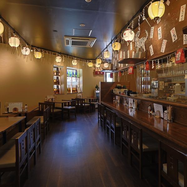 頭上には提灯が灯り、暖かな光で包まれる空間が広がります。窓際には日本酒の空き瓶が並べられていて、日差しに照らされるとガラス越しにキラキラと美しく輝きます。広々とした店内は落ち着いた茶色を基調としており、どこか懐かしく、居心地のいい雰囲気。仲間との食事も、一人の時間も、心地よく過ごせる空間です。