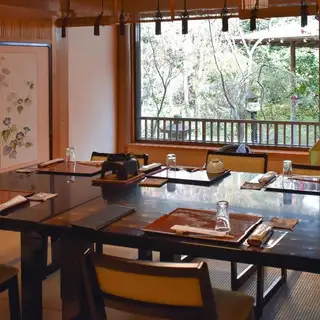 【椿の間(椅子席)】<定員:8名様><特徴:三宜庵(茶室)や紅葉と椿の眺めが良いお部屋です。>秋には真っ赤に色付いた紅葉をお楽しみいただけます。また、光沢のあるグリーンの葉が特徴の椿も。大きな窓から見える景色を眺めながらお召し上がりになるお食事はまた格別です。落ち着いた空間でごゆっくりお過ごし下さい
