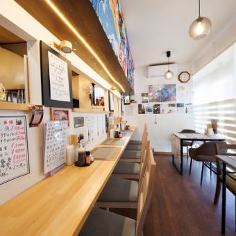 2名様掛けのテーブル席は、カップルやご夫婦、友人との語らいにぴったりの空間です。木目を基調とした明るく清潔感のある店内で、隣り合って食事を楽しめます。