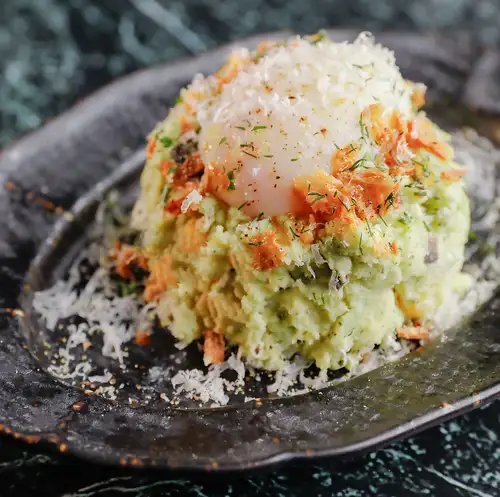 Genovese potato salad topped with a runny egg.