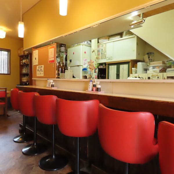 カウンター席は、料理をじっくり楽しむのにぴったり。赤い椅子が印象的で、居心地の良さを感じさせます。オープンキッチンからは、料理の様子を見ながら、温かい料理を味わえる特別な体験ができます。