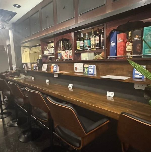 【カウンター席】クラフトジンやナチュラルワインのボトルがずらりと並ぶカウンター席は、アジアン酒場ならではの雰囲気を一番肌で感じられる特等席です！一人飲みはもちろん、肩を並べて語り合いたいデートにも最適♪スタッフとの距離も近く、おすすめのお酒を相談しながら楽しめるのも魅力です！