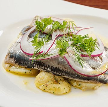 Sardines marinated in lemon and red wine vinegar, served with potato, red onion and herb salad