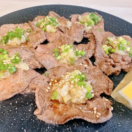 炭烤牛舌配葱花和盐。