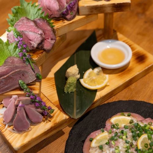 A lineup of various dishes including steaks, meat sashimi, and pizza