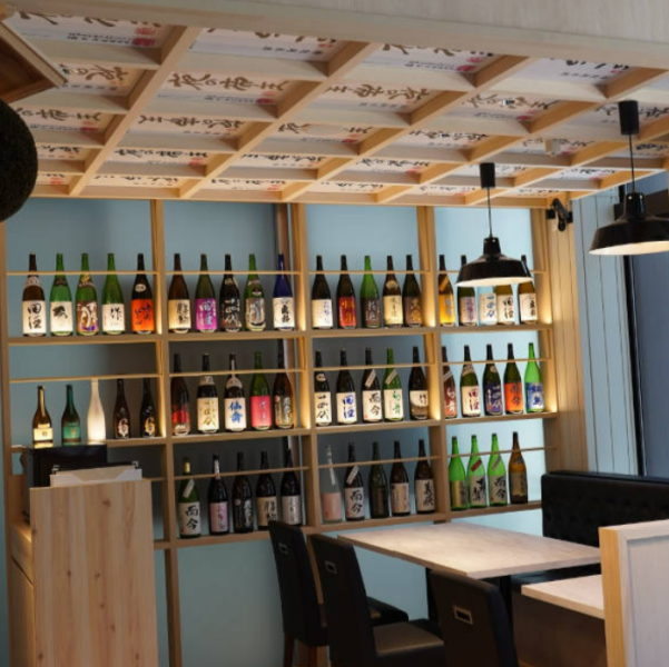 店内奥には、定番からプレミアムの希少な日本酒を取り揃えています。おすすめの飲み比べセットで、香りや風味、甘み、辛さなど、産地ごとの銘柄の違いを楽しむことができます。常時70種類以上の日本酒を心行くまで堪能できる環境で、日本酒の奥深い世界をぜひご体験ください。ぜひ、特別な一杯を見つけてください！