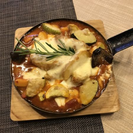 柔軟的牛筋和牛內臟用巴斯克風格的辣番茄醬燉製，配上夏季蔬菜和土豆，再淋上融化的奶酪