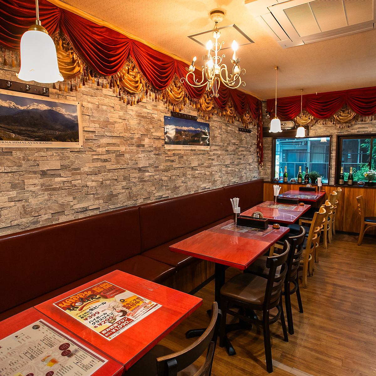 A chandelier and a burgundy sofa accentuate the ethnic decor.