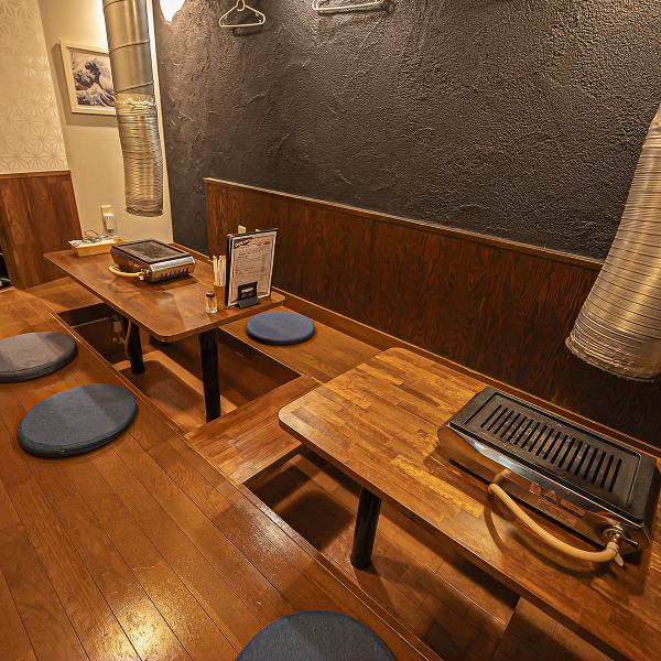 【カジュアルから接待まで対応】 暗めの内装と間接照明が、心地よい落ち着きを演出するテーブル席。明かりを吸収するオブジェが、周囲の賑やかさを適度に遮断し、隣を気にせず会話に集中できる環境を提供。少人数での食事や、大切な方との語らいにふさわしい空間です。