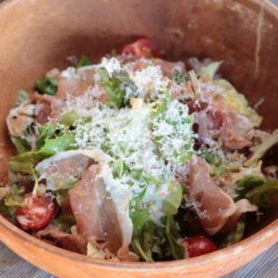 Freshly grated parmigiano cheese and prosciutto caesar salad