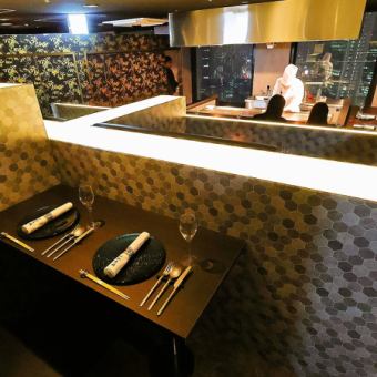 【情侶座】此座位供兩人使用。雖然距離鐵板燒吧台座位稍遠,但高台座位可以讓您欣賞到中央鐵板燒吧台的烹飪過程和表演。對於約會或週年紀念等特殊場合,我們建議您提前預訂。*這是姊妹店的照片。