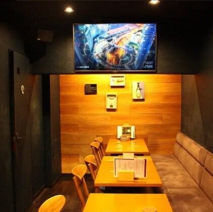 <p>温かみのある照明と木の質感が心地よい、落ち着いた空間。壁にはアートやボトルが飾られ、テレビには夜景が映し出されていて、都会的でありながらも親しみやすい雰囲気。</p>