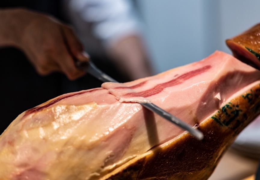 A raw ham cut by Chef Nakamura, who won the 2011 Iberico Ham Cortador Contest, which competes for cutting accuracy, speed, and beauty, sponsored by the government of Andalusia, Spain.We use carefully selected raw ham logs from Bellota, the highest quality Iberico ham.Please enjoy the balance of fat and meat and the flavor that spreads in your mouth.