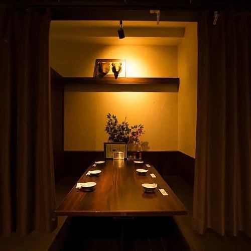 【半個室：6～8名様】カーテンで仕切ることができるプライベート空間で、周りを気にせずお食事をお楽しみいただけます。愛煙家の方にうれしい喫煙可能である点も魅力の一つ。間接照明に包まれた和の落ち着いた雰囲気で、ゆったりとおくつろぎください。
