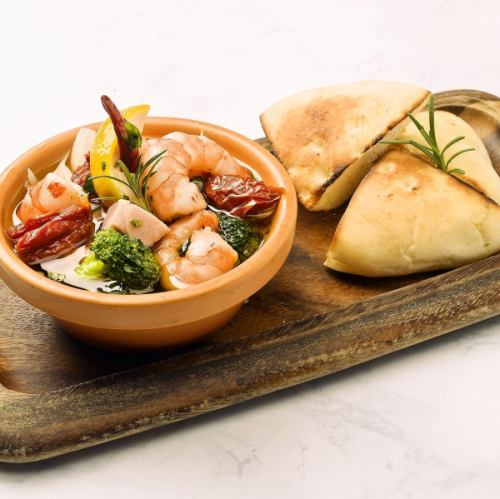 Ajillo with lots of shrimp and cherry tomatoes served with focaccia