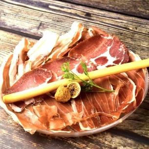 Assortment of 3 types of freshly shaved ham served with grissini