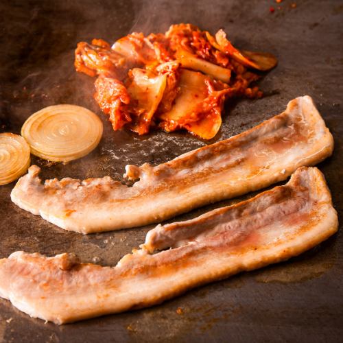 [Hot Samgyeopsal cooked on a large hot plate] is served immediately! It is a classic Korean dish that we are proud of.