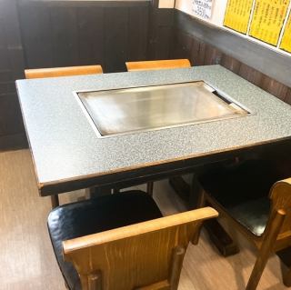 【1階テーブル席】少人数のグループや、ご家族での利用にぴったりな4名様用テーブル席♪目の前には鉄板があり、焼きたての料理をお楽しみいただけます！友人との楽しいひとときや、家族団らんの特別な時間をお過ごしください◎