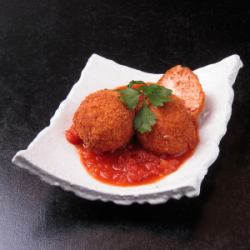 自製arancini（飯糰）配番茄和磨碎的奶酪