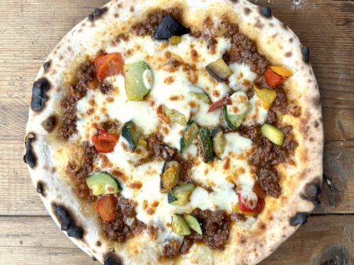 Bolognese pizza with colorful vegetables and mozzarella cheese