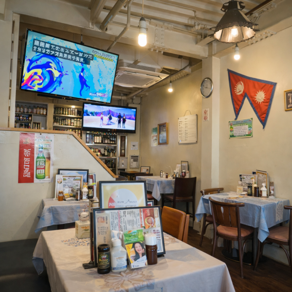 天井の梁やペンダントライトがつくる、どこか異国情緒を感じる落ち着いた店内。壁に飾られた国旗やテレビの映像がほどよい賑わいを演出し、気取らず過ごせる空間です。お一人様からグループまで、ゆったり食事を楽しめます。