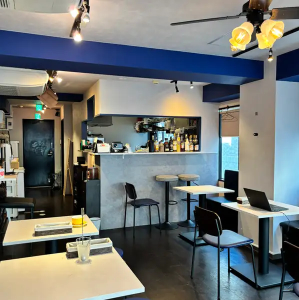 ネイビーブルーの梁と木の温もりが調和する、大人の隠れ家カフェ&バー。ゆったりとしたソファ席で流れる贅沢なランチタイムを。お一人様でも寛げる落ち着いた空間で、ワークスペースとしてもご利用いただけます。
