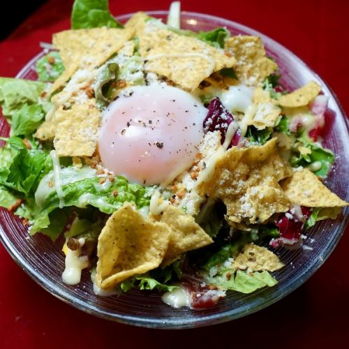 Caesar salad with nacho chips and hot egg