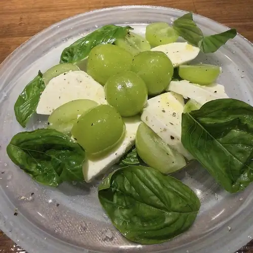 卡普雷塞沙拉配 Shine Muscat 葡萄和马苏里拉奶酪。