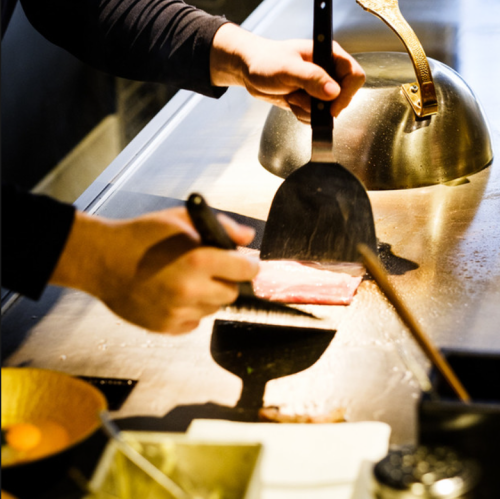 A restaurant where chefs cook food right in front of you and you can enjoy it with all your senses