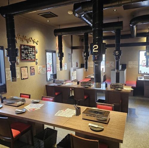 4名様用のテーブル席や2名様用テーブル席など、多彩なお席が機能的に配置されています。木目調のテーブルに赤いチェアが映える清潔感のある内装で、活気がありながらも落ち着いた雰囲気です。