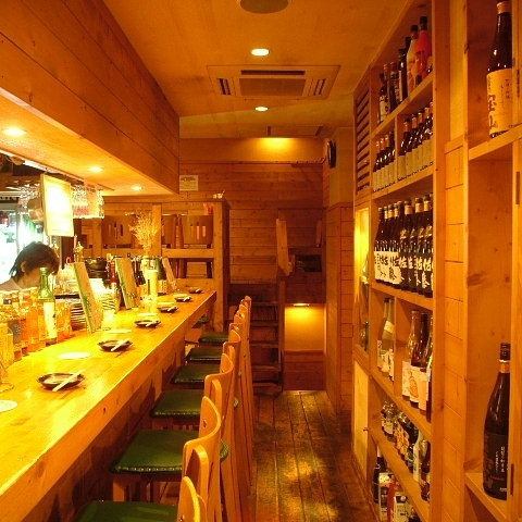 みんなに愛される小粋なダイニングのカウンター席は背中にこだわりのお酒が並びます。キッチンは低めにしており、お客様の会話を大切に、くつろいでいただけるカウンターです。