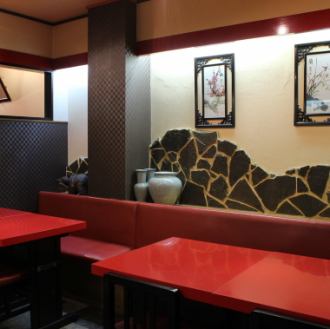 赤を基調としつつ、落ち着いた重厚感のある店内。テーブル席多数。