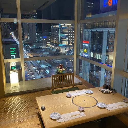 [Overlooking the night view of Sapporo Station from a seat surrounded by glass]