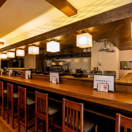 お一人様でも気軽に楽しめる！活気あふれる1階カウンター席♪ 目の前で調理の様子を眺めながら、お食事とお酒をお楽しみいただけるカウンター席です。全14席ございますので、お仕事帰りにお一人でふらっと立ち寄りたい時や、サクッと飲みたい時に最適です。