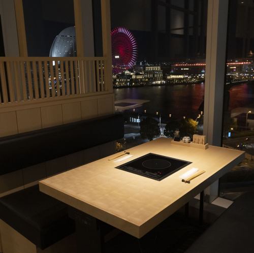 <p>窓の向こうに広がるのは、みなとみらいが誇る光の芸術。地上7階から見下ろす景色は、コスモクロックの鮮やかな彩りとベイエリアの水面が織りなす、まさに宝石箱。昼は開放的な青空と海風を感じさせ、夜は煌びやかな夜景が鍋の湯気までもドラマチックに演出</p>