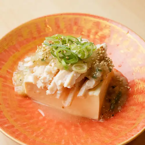 Cold tofu topped with steamed chicken and drizzled with green onion and salt sauce.
