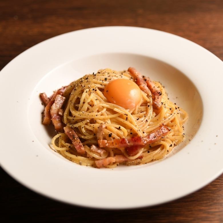 Carbonara topped with egg yolk