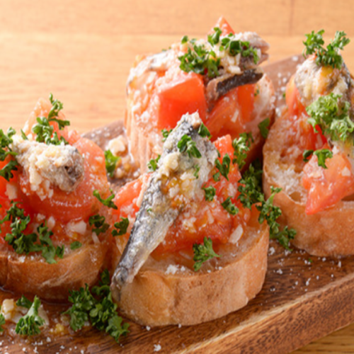 Adult bruschetta with smoked sardines and warm tomatoes