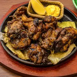 Grilled free-range chicken on a hot plate over charcoal