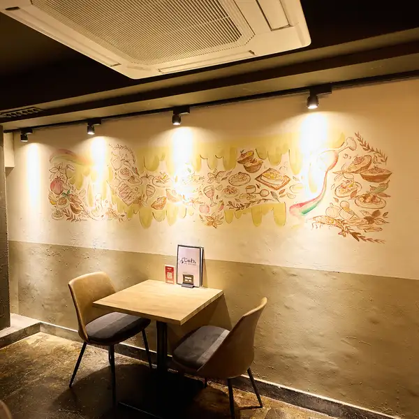 壁面を彩るアートや柔らかな照明が印象的な店内。おしゃれさがありながらも気軽に立ち寄れる雰囲気で、デートや女子会にもおすすめです。