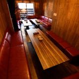 【3階フロア】赤いソファーとウッド調の大きなテーブルがある落ち着いた雰囲気の3階。貸切利用の際は15～25名様でお使いいただけます。奥行きのあるリッチな空間は大型パーティーやビジネスシーンの宴会などにもお使いいただけます。