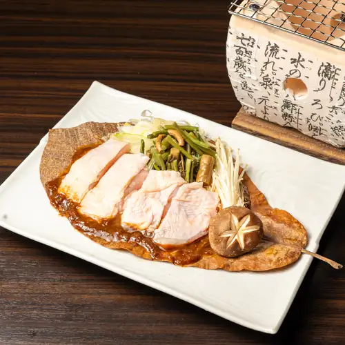 烤岩井雞配野生蔬菜和味噌醬，用玉蘭葉包裹。